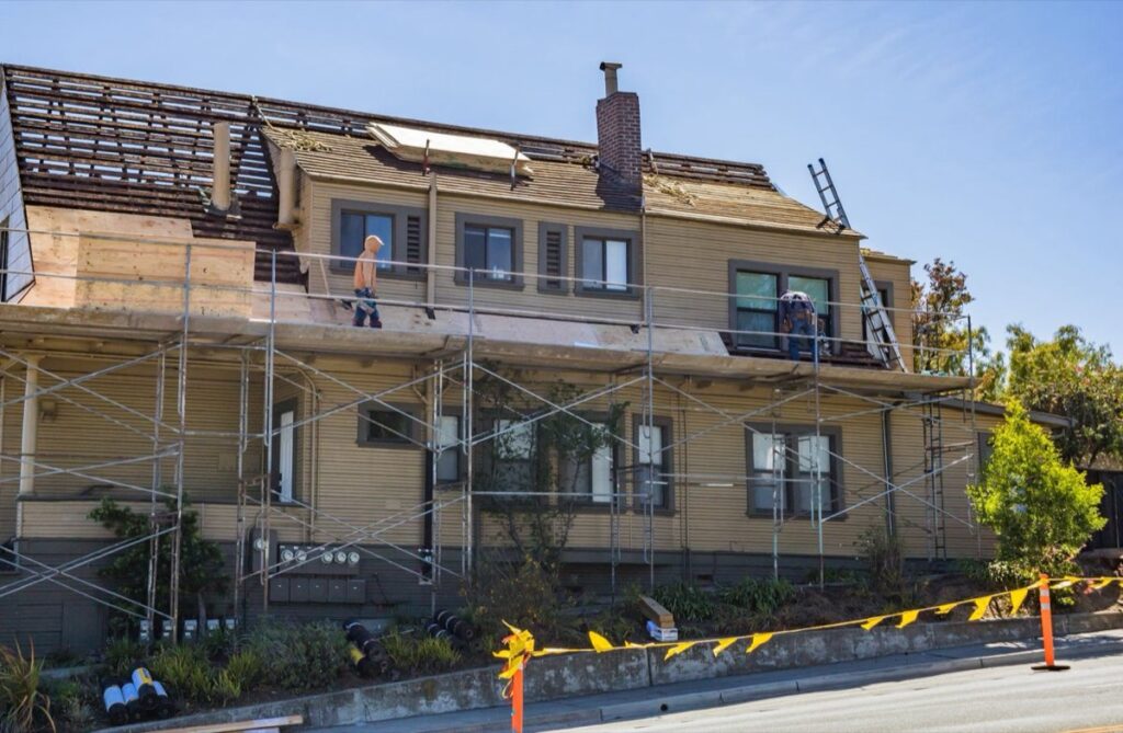 Exterior EIFS remediation in progress with scaffolding on a home